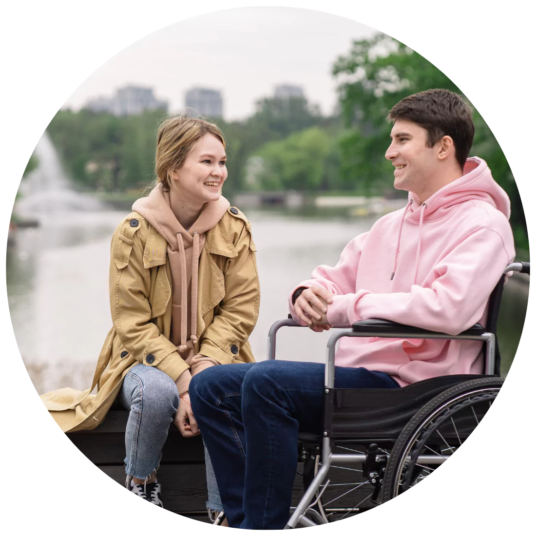 Disabled man and his support worker in a park happily talking