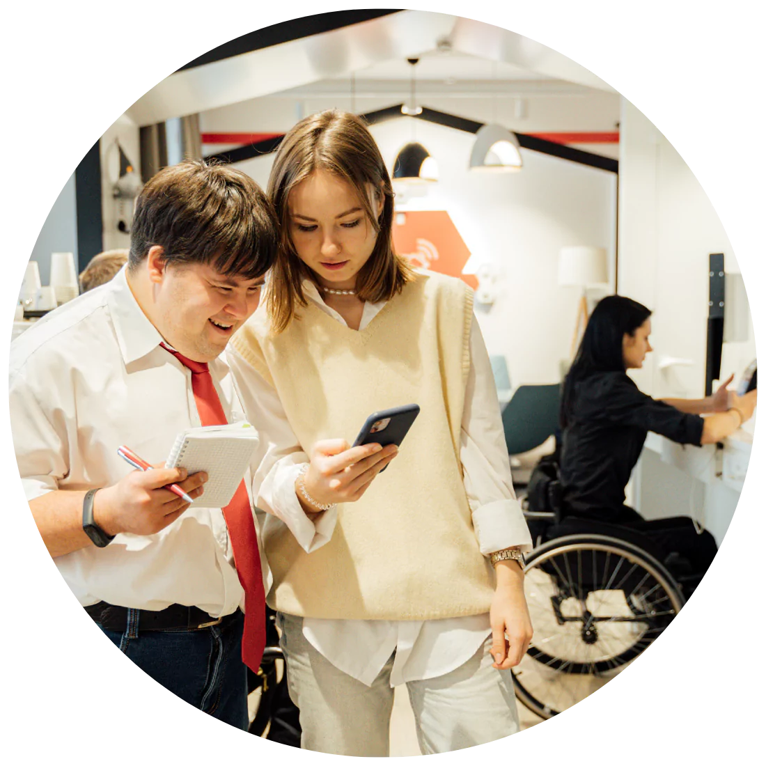 Disabled man and his support worker smiling while looking at the phone